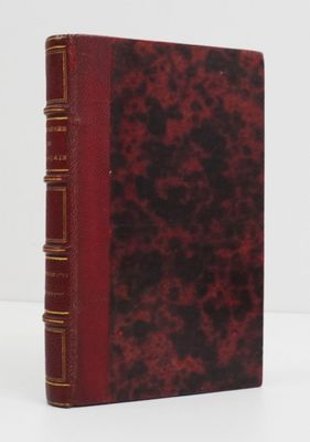 a red book sitting on top of a white table next to a white wall