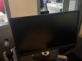 a computer monitor and keyboard on a desk in front of a window