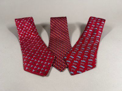two red neck ties with different designs on them on a white surface