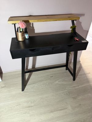 un bureau noir avec un plateau en bois et des tiroirs