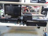 a laptop and printer sitting on a cart in a garage