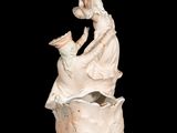 a statue of a man and a woman sitting in a vase