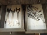 many tools in the drawer of a kitchen cabinet