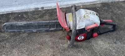 a chainsaw that is laying on the ground next to a building