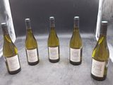 six bouteilles de vin sont alignées sur un comptoir