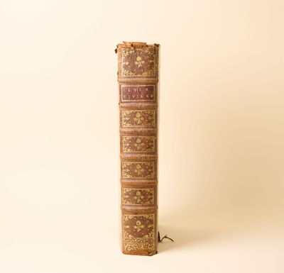 un vieux livre posé sur une table, à côté d'une lampe