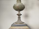 a vase with a bird on top of it sitting on a table