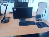 a desk with a monitor, keyboard and mouse on it
