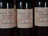 three bottles of red wine are lined up on a table