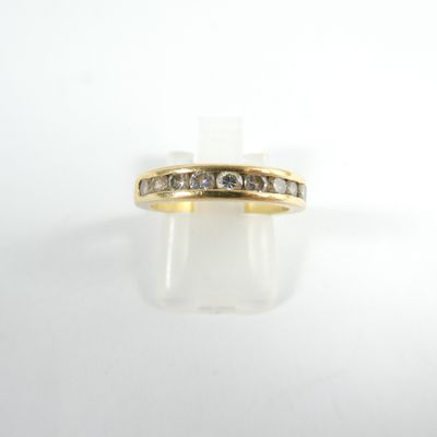 gros plan d'une bague en or avec des diamants sur une surface blanche