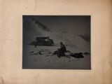 a black and white photo of a man sitting in the snow