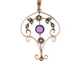 a close up of a pendant with a purple stone on it