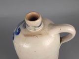 a small white vase with a blue design on it