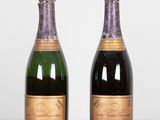 two bottles of champagne sitting on top of a table next to each other