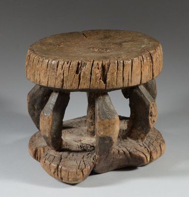 an old wooden stool with a wooden seat on it