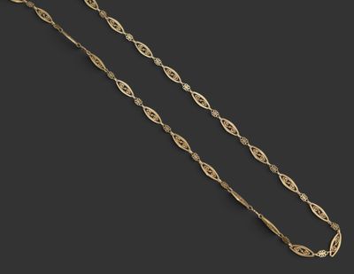 un collier en or composé d'une longue chaîne posée sur une surface noire