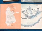two books on a blue table with a picture of a castle