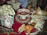 a red table with a cup of tea and stuffed animals on it