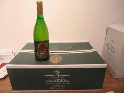 une bouteille de vin posée sur une boîte, elle-même posée sur une table