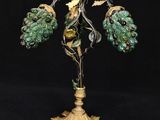 une lampe en verre vert avec un pied doré orné de feuilles