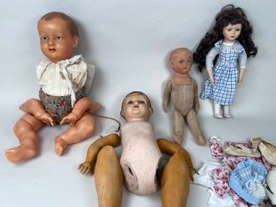 three dolls sitting next to each other on a white surface