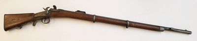 un fusil en bois accroché au mur, avec une arme posée dessus