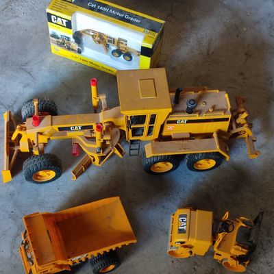 un camion jouet jaune et un camion-benne côte à côte