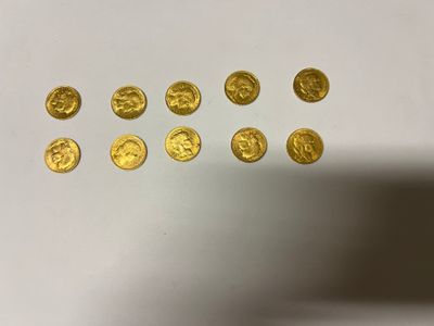 a close up of a bunch of gold coins on a white surface