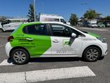 a green and white car parked on the side of the road