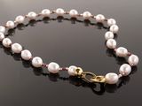a close up of a white pearl necklace on a black surface