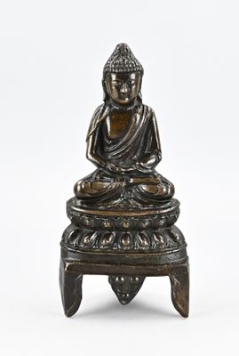 une image représentant une statue de Bouddha assis sur un tabouret
