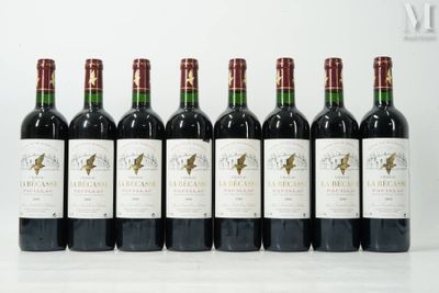 six bouteilles de vin sont alignées sur une surface blanche