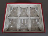 six empty wine glasses in a red box on a table