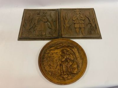 deux plaques en bronze représentant un homme et une femme dans une forêt