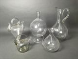 three glass vases and a glass pitcher on a table