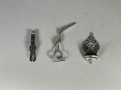 un objet en argent et une paire de ciseaux posés sur une table