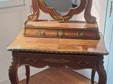 a wooden vanity with a mirror and a rug on the floor