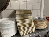 a stack of plates and bowls on a counter in a kitchen