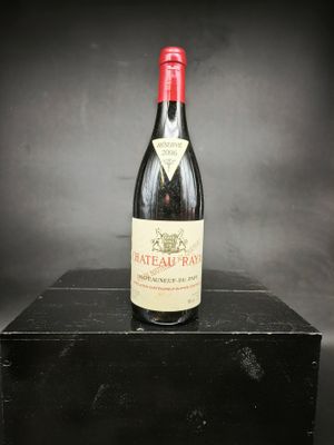 une vieille bouteille de vin posée sur une boîte noire