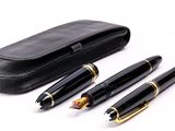 two pens and a case are sitting on a white surface