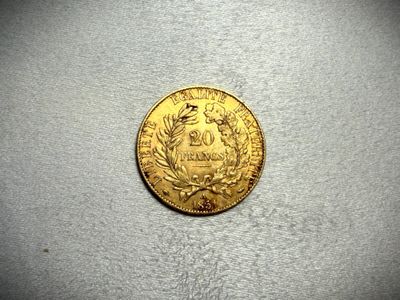 a close up of a gold coin on a white surface