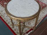 a table with a marble top on a rug in a living room