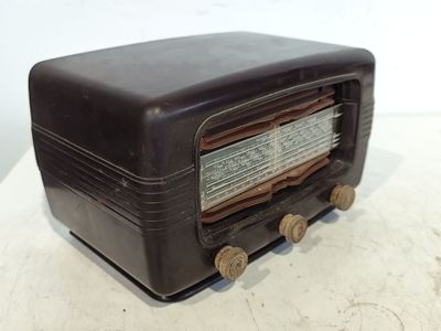 une vieille radio posée sur une table près d'un mur blanc