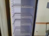 a small refrigerator with its door open in a kitchen