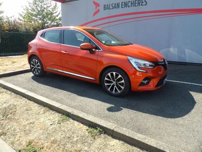 La voiture orange est garée devant un immeuble.