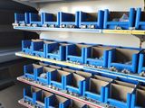 a shelf with lots of blue bins on it