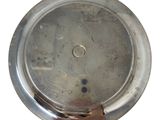 a silver plate with a hole in it on a white surface