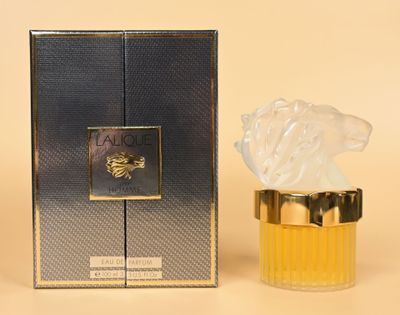 a close up of a bottle of perfume next to a box