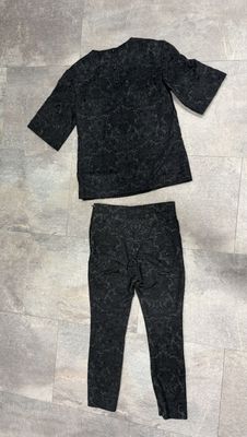 black sweater and leggings laying on the floor next to a pair of shoes