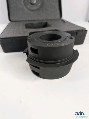 un gros plan d'un objet noir sur une surface blanche
